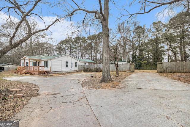 view of side of property with crawl space, fence, and concrete driveway