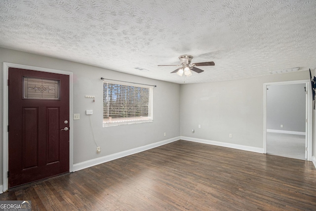 foyer featuring baseboards, visible vents, a ceiling fan, dark wood-style flooring, and a textured ceiling