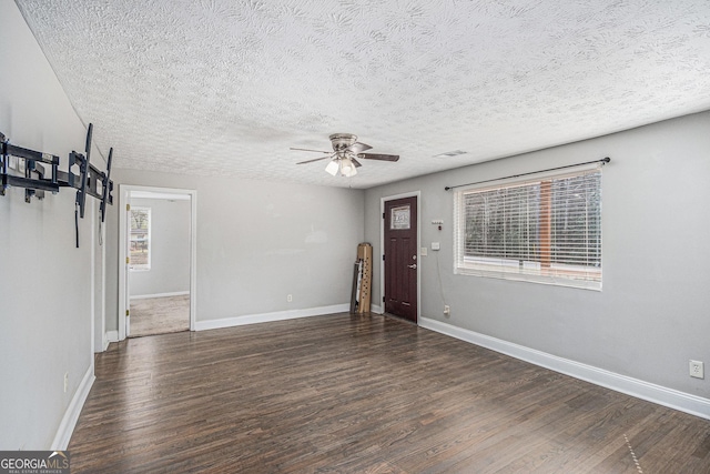 unfurnished living room featuring ceiling fan, wood finished floors, and baseboards