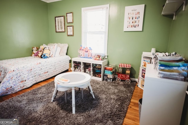 bedroom featuring wood finished floors and baseboards