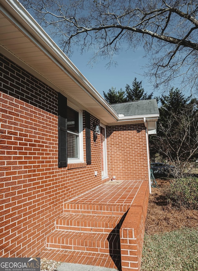 view of exterior entry with brick siding