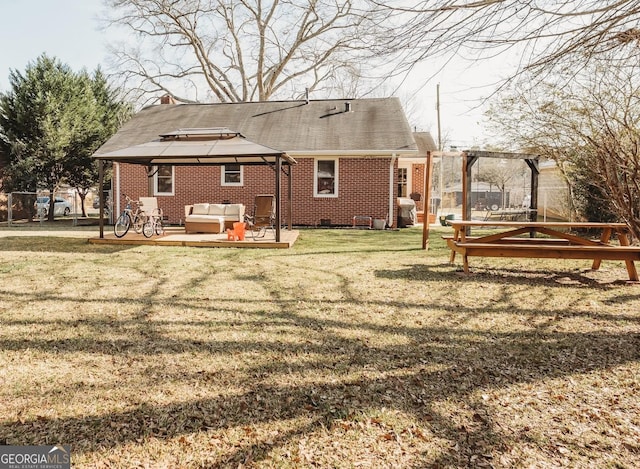 back of property featuring brick siding, a chimney, a lawn, a gazebo, and an outdoor living space