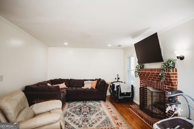 living room featuring dark wood-type flooring, a fireplace, recessed lighting, and crown molding