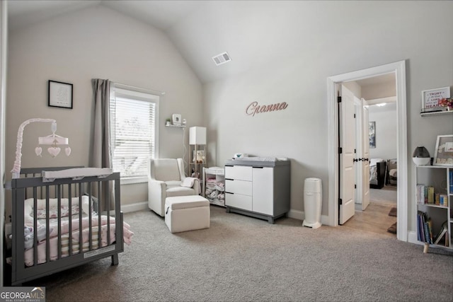 carpeted bedroom featuring lofted ceiling, baseboards, visible vents, and a nursery area