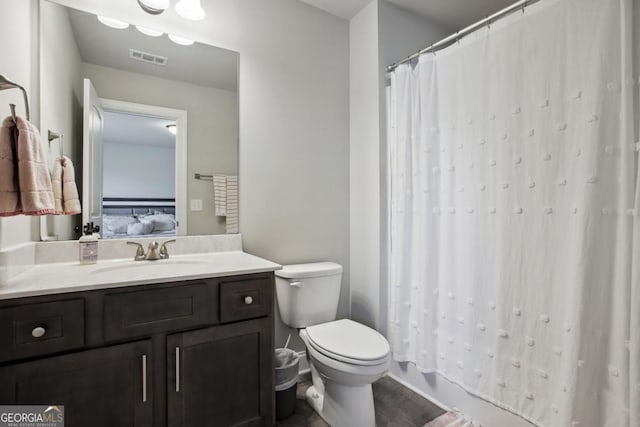 bathroom with toilet, vanity, visible vents, and ensuite bathroom