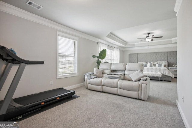 interior space featuring ornamental molding, a tray ceiling, visible vents, and baseboards