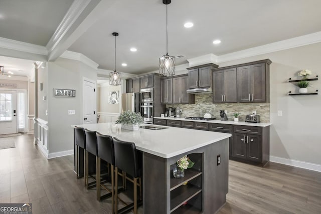 kitchen with open shelves, stainless steel appliances, tasteful backsplash, dark brown cabinets, and an island with sink