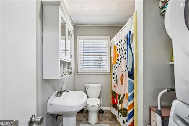 full bathroom featuring stacked washer / dryer, a shower with curtain, a sink, and toilet