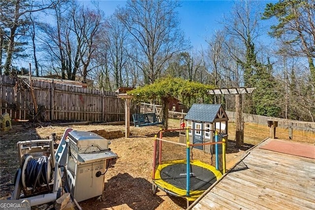 view of play area with a fenced backyard and a trampoline