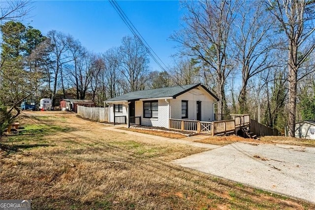 view of front of house featuring driveway, a front yard, a porch, and brick siding