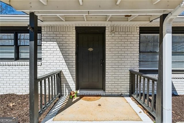 doorway to property with brick siding