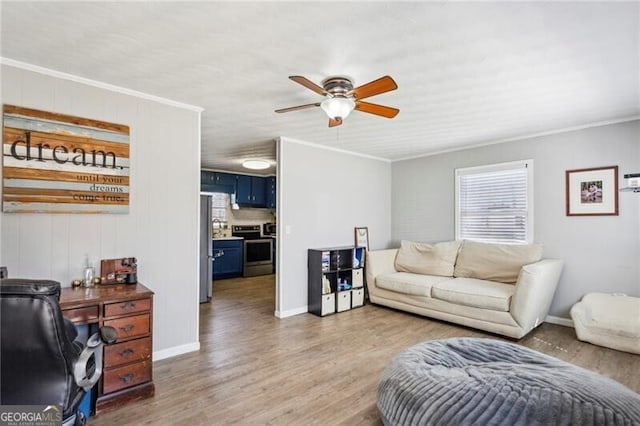 living area with ornamental molding, light wood-type flooring, baseboards, and a ceiling fan