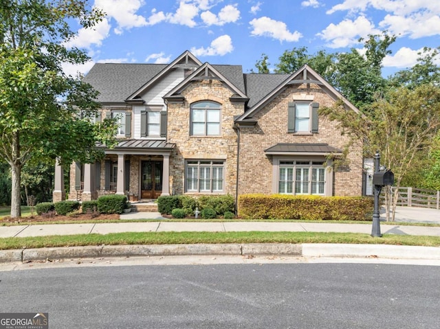 craftsman-style home with metal roof, a standing seam roof, and fence