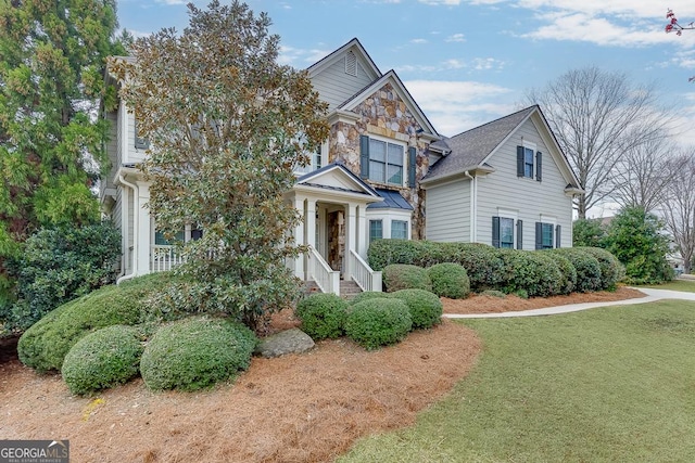 view of front of house with a front yard and stone siding