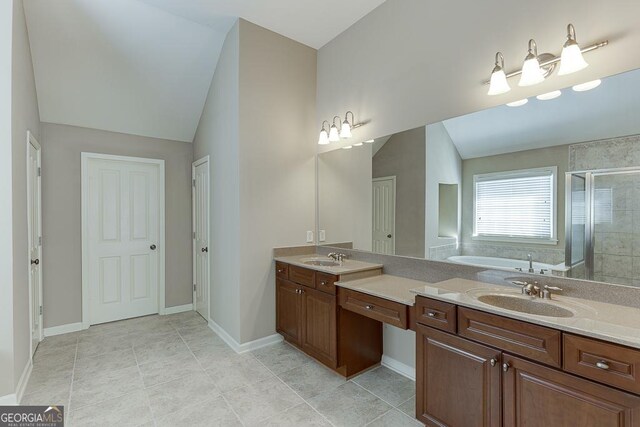 bathroom with a garden tub, vanity, baseboards, vaulted ceiling, and a shower stall