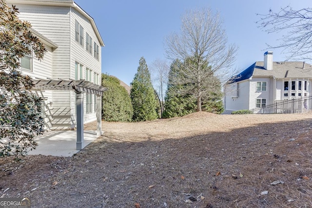 view of yard with fence, a pergola, and a patio