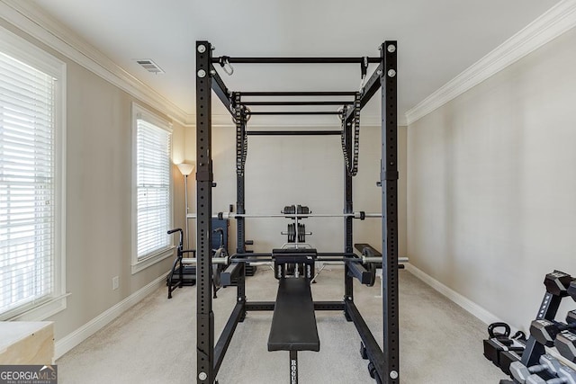 exercise room featuring baseboards, visible vents, and ornamental molding