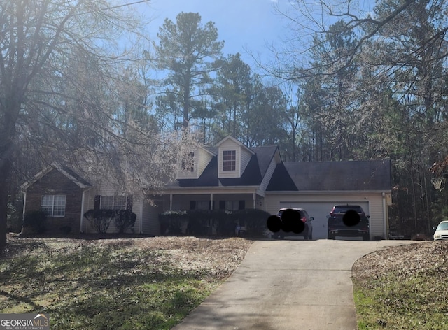 new england style home with concrete driveway and a garage