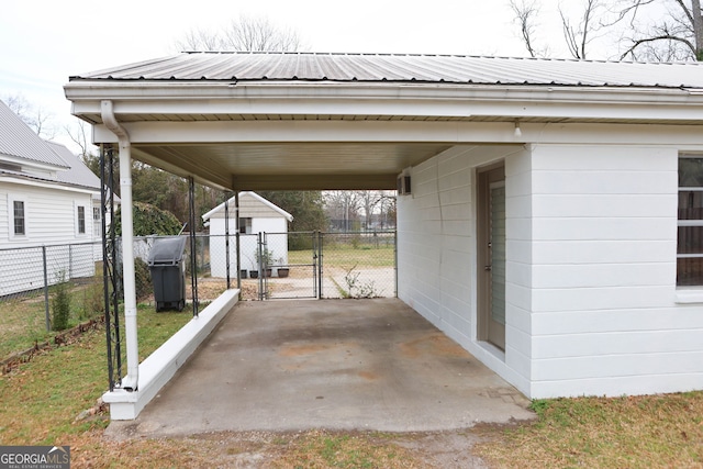 view of parking / parking lot with an attached carport, a gate, fence, and driveway