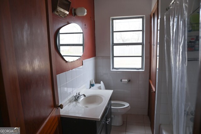 bathroom with plenty of natural light, tile walls, toilet, and tile patterned floors