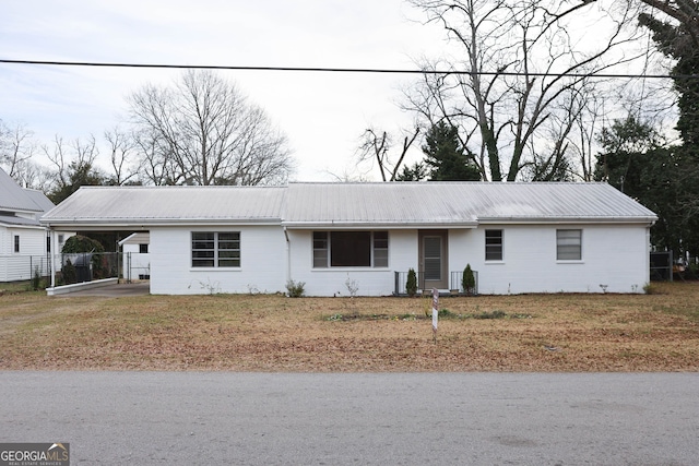 ranch-style home featuring metal roof, fence, and an attached carport