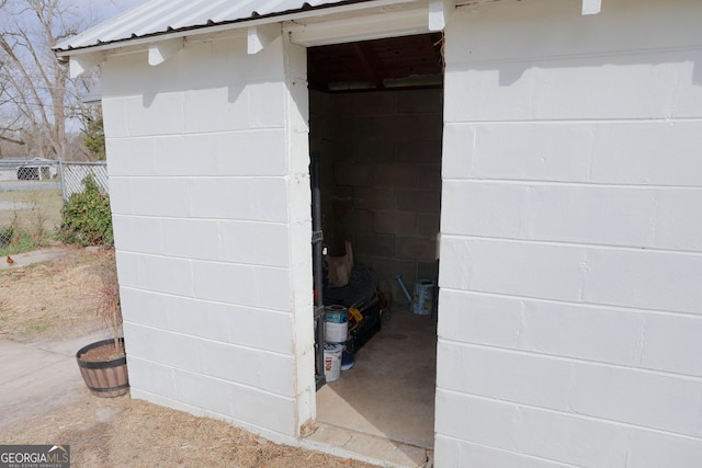 details with concrete block siding, fence, and metal roof