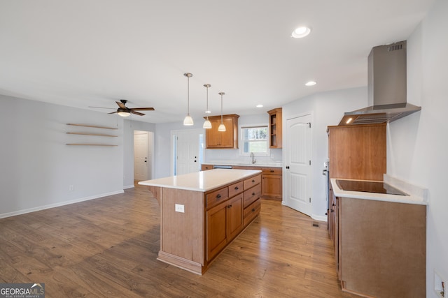 kitchen featuring wall chimney exhaust hood, brown cabinets, wood finished floors, a center island, and open shelves