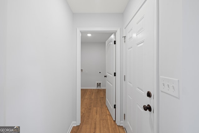 hallway with baseboards and light wood-style floors