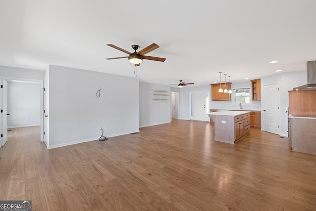 unfurnished living room featuring baseboards, ceiling fan, light wood finished floors, and recessed lighting