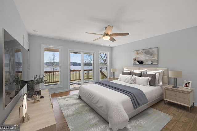 bedroom with ceiling fan, access to outside, and wood finished floors