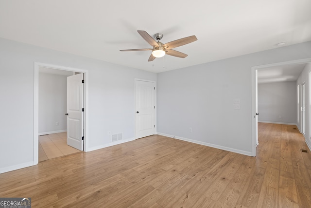 unfurnished bedroom featuring ceiling fan, light wood-type flooring, visible vents, and baseboards