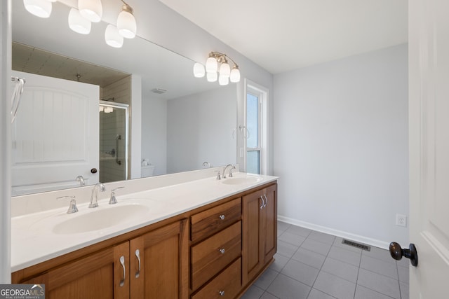 bathroom with visible vents, an enclosed shower, a sink, and tile patterned floors