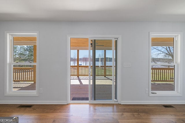 doorway with a healthy amount of sunlight, visible vents, and wood finished floors