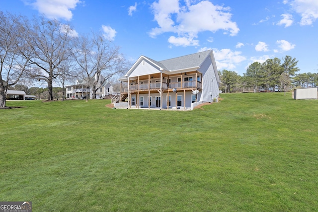 rear view of house with a ceiling fan, a yard, and a wooden deck