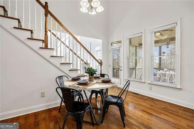 dining area with stairs, baseboards, and wood finished floors