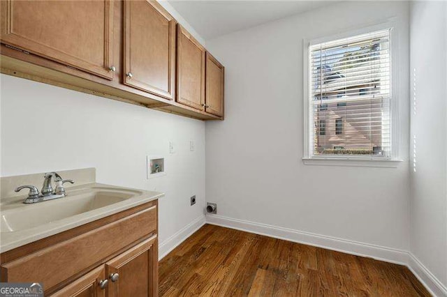 washroom with a sink, hookup for a washing machine, electric dryer hookup, and baseboards