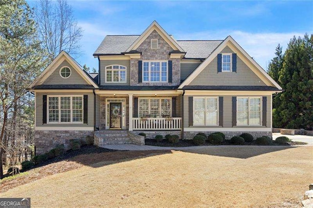 craftsman-style house featuring stone siding and covered porch