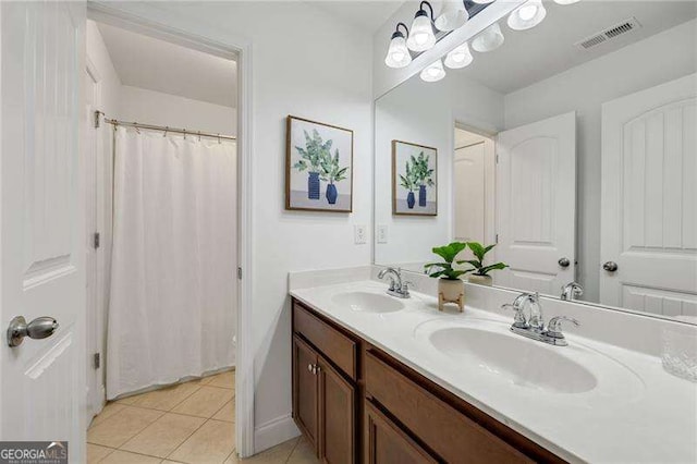 bathroom with double vanity, visible vents, a sink, and tile patterned floors