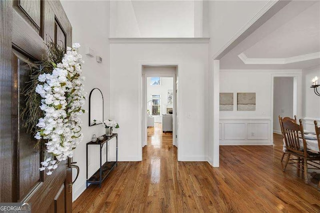 foyer entrance featuring wood finished floors and crown molding