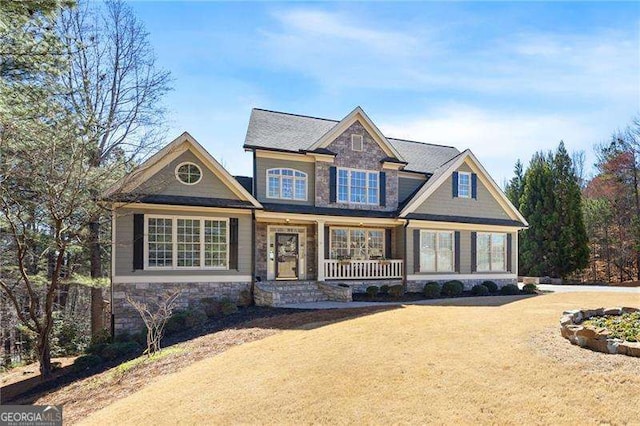 craftsman inspired home featuring stone siding and a porch