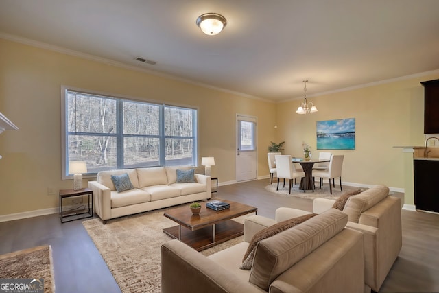 living room with baseboards, visible vents, wood finished floors, and ornamental molding