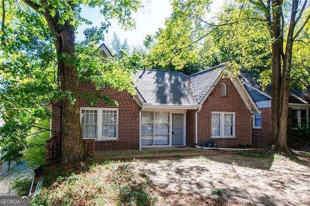 view of front of house featuring brick siding and a shingled roof