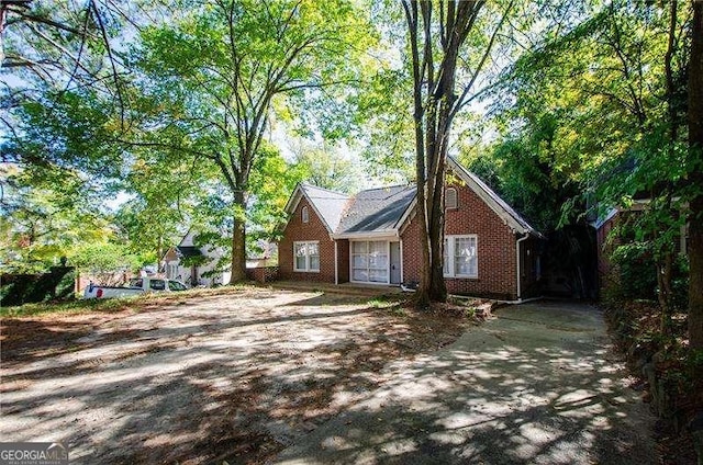 view of property exterior with brick siding and driveway