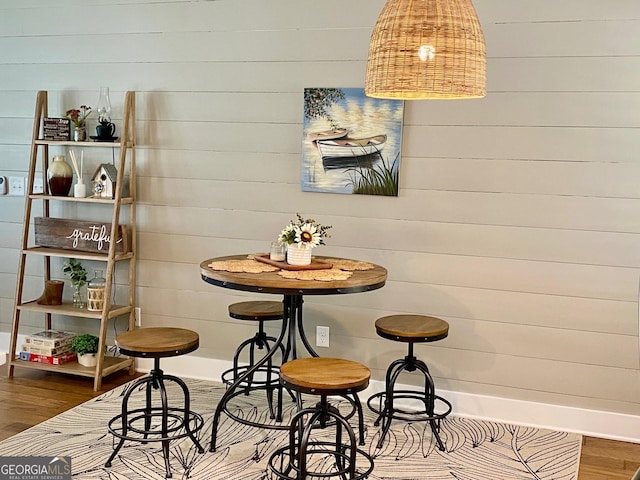 dining space featuring wood walls and wood finished floors