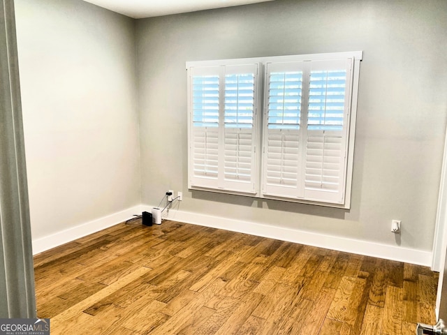 spare room featuring wood finished floors and baseboards