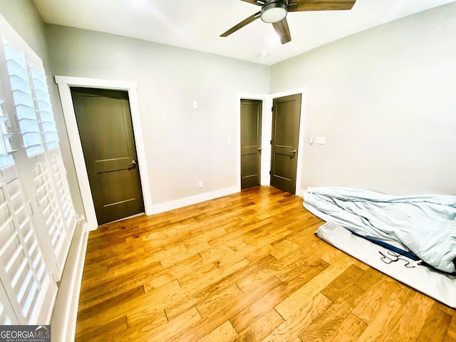 unfurnished bedroom featuring ceiling fan, baseboards, and wood finished floors