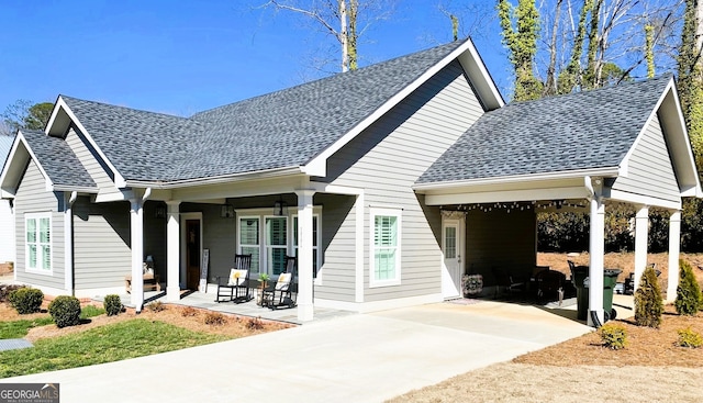 view of front of property featuring driveway, covered porch, and roof with shingles