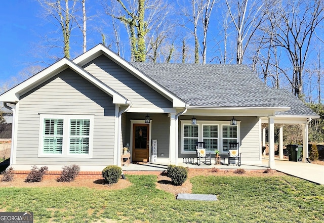 view of front of house with driveway, roof with shingles, and a front yard