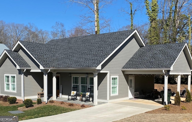 view of front of home with a shingled roof, a porch, and a carport