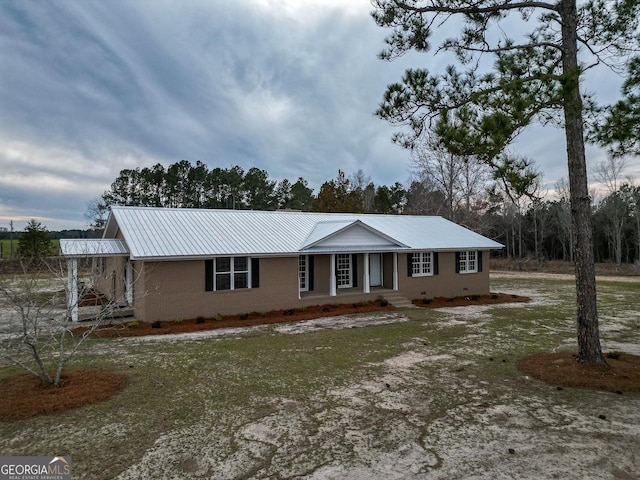 single story home with crawl space, brick siding, and metal roof